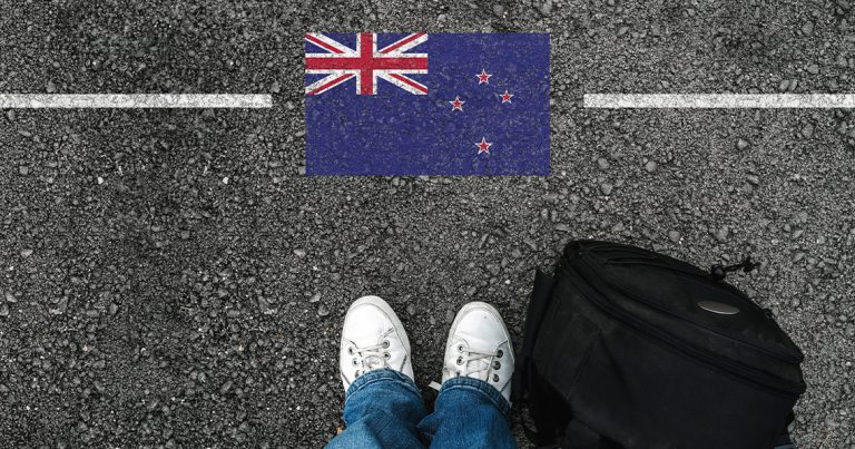 A man with white shoes and flag of New Zealand stock phot