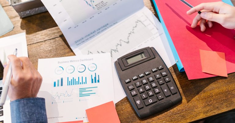 people sitting at a table with papers and a calculator.