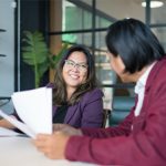 Two people in a meeting, talking and smiling