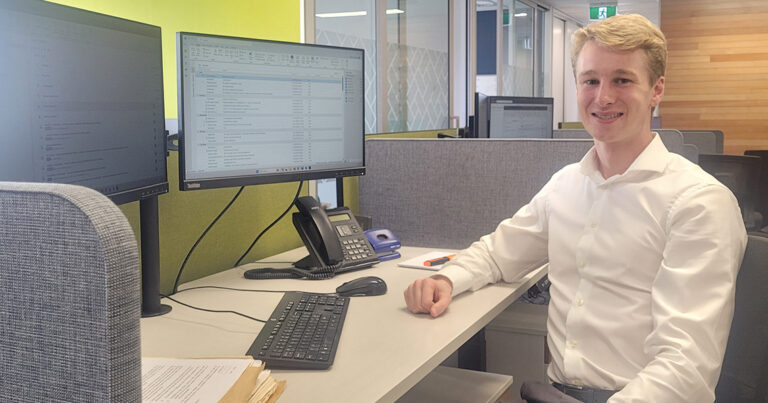 Donald in professional clothing sitting at desk