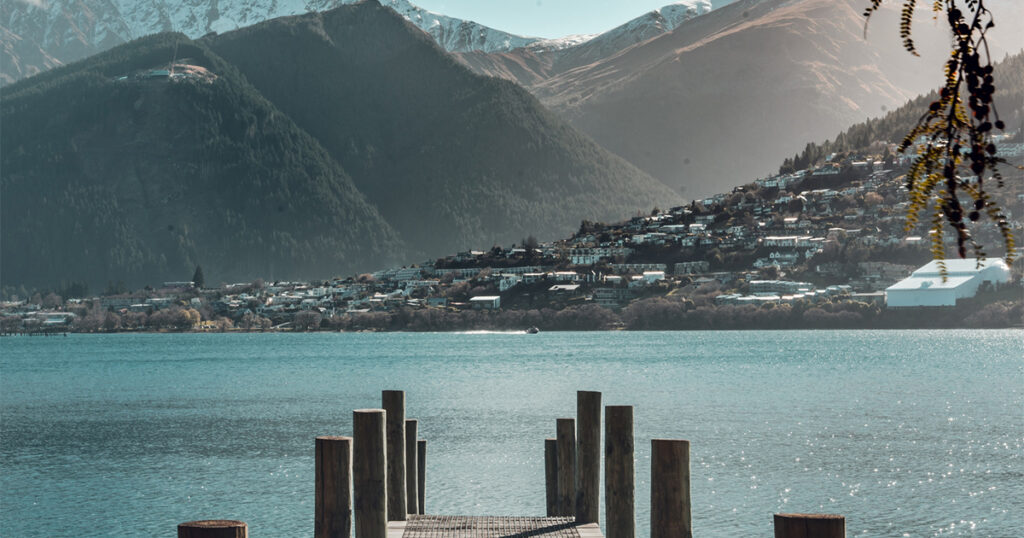 Scenic view of Queenstown, New Zealand from a lakeside pier with mountains in the background, a popular destination for property investment under the Golden Visa program og image