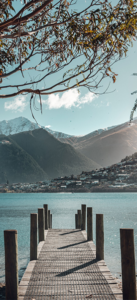 Scenic view of Queenstown, New Zealand from a lakeside pier with mountains in the background, a popular destination for property investment under the Golden Visa program