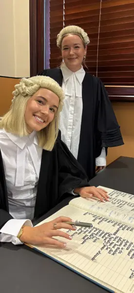 Millie-Fox-from-AWS-Legal-admission-to-the-bar-signing-with-colleague